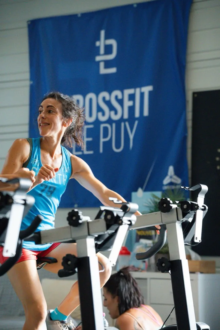 Athlète sur rameur devant la bannière CrossFit Le Puy